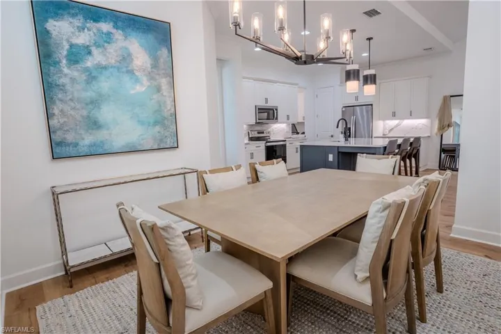Dining room featuring light wood-type flooring, a chandelier, and sink