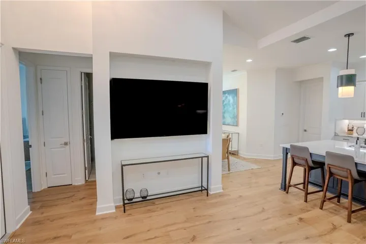 Living room with light wood-type flooring and vaulted ceiling