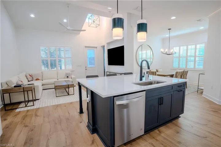 Kitchen featuring pendant lighting, a center island with sink, sink, and stainless steel dishwasher