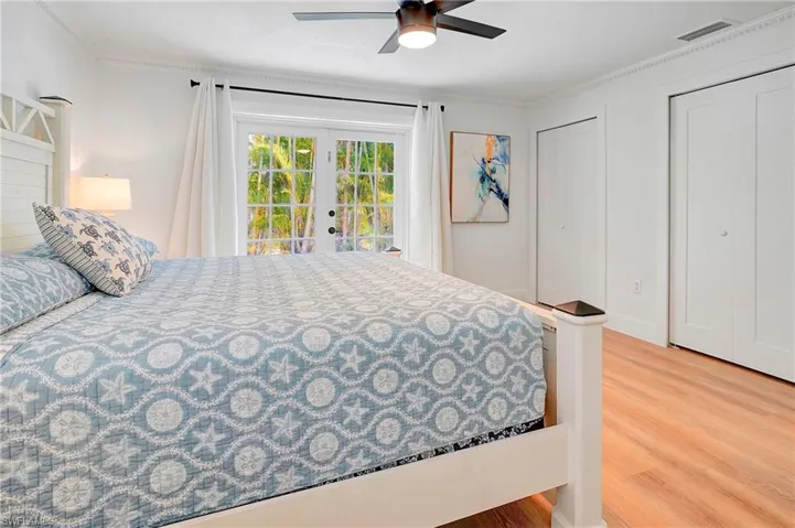 Bedroom with french doors, access to exterior, ornamental molding, ceiling fan, and light hardwood / wood-style flooring
