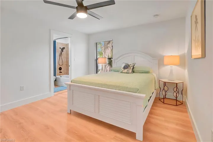 Bedroom featuring light wood-type flooring, ceiling fan, and ensuite bathroom