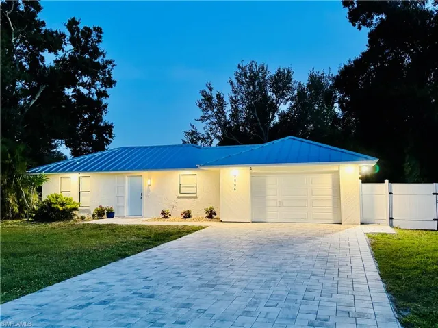 Ranch-style home featuring decorative driveway, an attached garage, a metal roof, and a standing seam roof