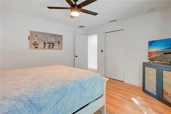 Bedroom with ceiling fan and hardwood / wood-style floors