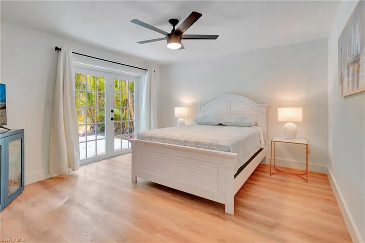 Bedroom with access to exterior, light hardwood / wood-style flooring, ceiling fan, and french doors