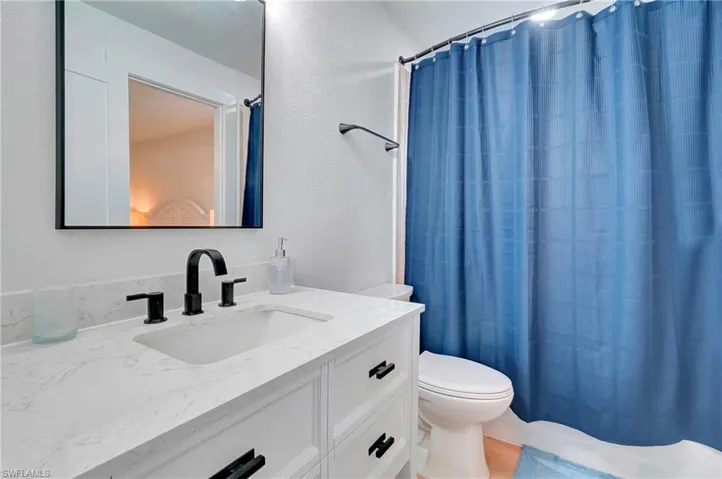Bathroom featuring hardwood / wood-style flooring, toilet, and vanity