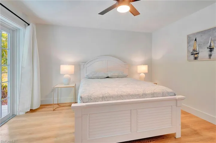 Bedroom with light hardwood / wood-style floors, access to exterior, and ceiling fan