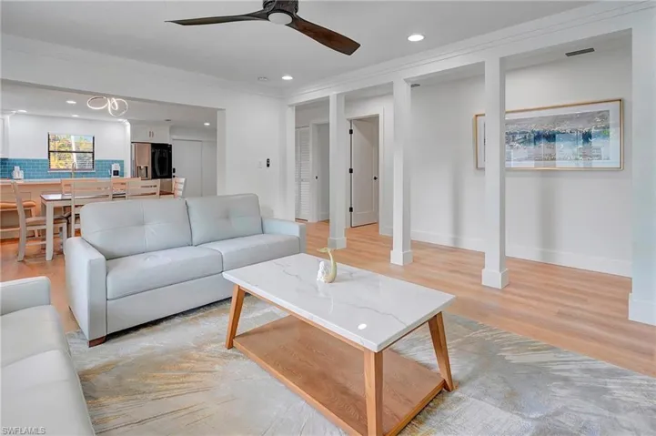 Living room with crown molding, light hardwood / wood-style floors, and ceiling fan