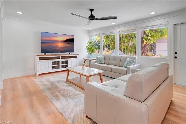 Living room featuring ceiling fan, light hardwood / wood-style flooring, and crown molding
