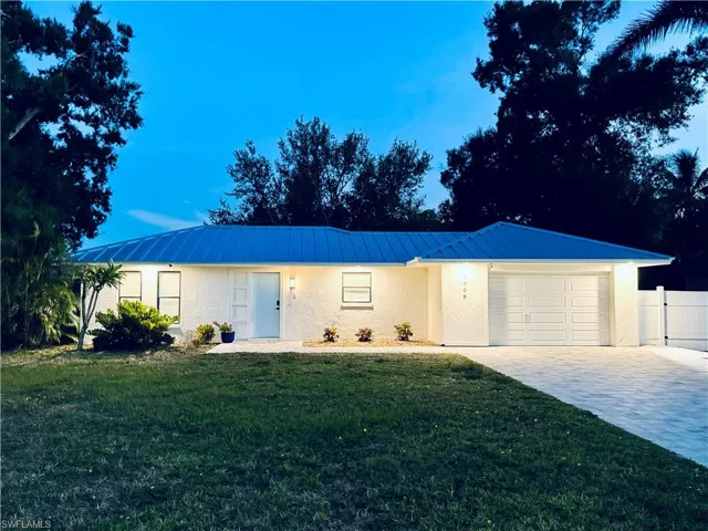 Single story home featuring a garage, stucco siding, decorative driveway, a metal roof, and a standing seam roof