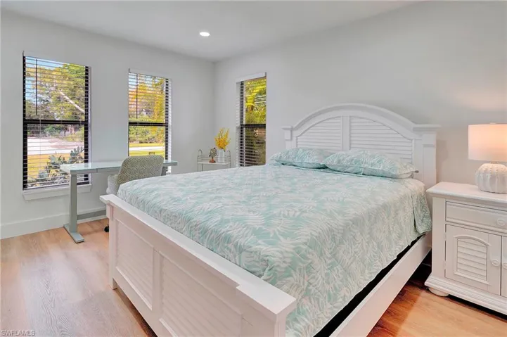Bedroom with light hardwood / wood-style flooring and multiple windows