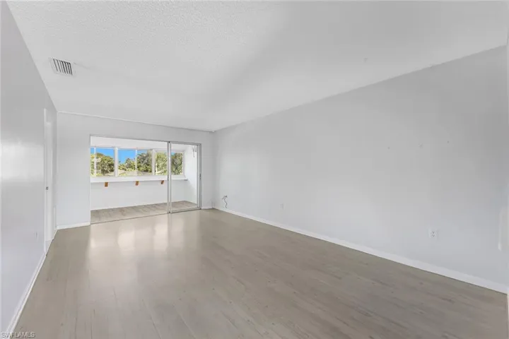 Empty room featuring a textured ceiling and hardwood / wood-style floors