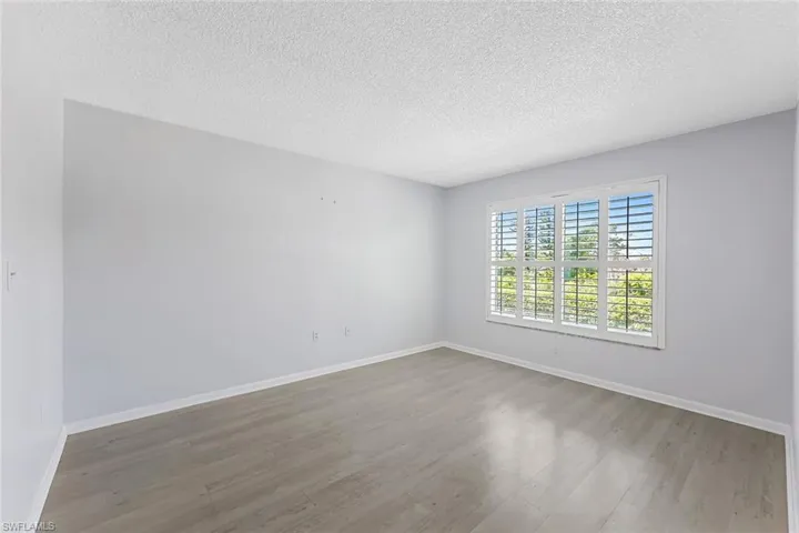 Empty room featuring a textured ceiling and hardwood / wood-style floors