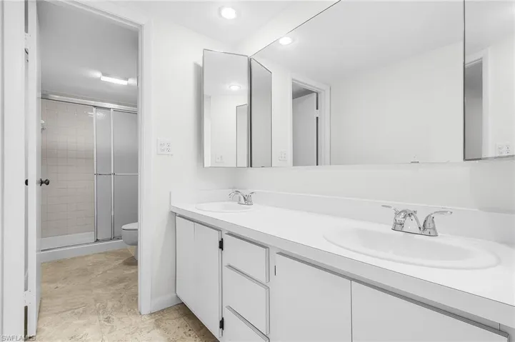 New dual sinks and simple white cabinets in the master bathroom. Dual medicine cabinets are functional and pretty.