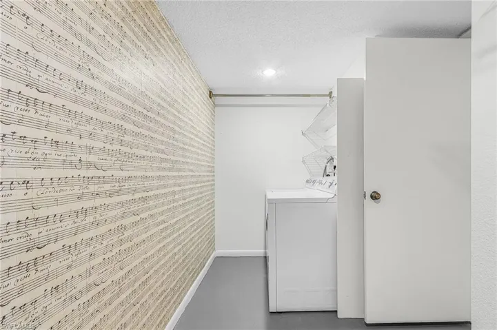 The spacious laundry room has a side by side washer & dryer w/hanging rack and extra storage space.