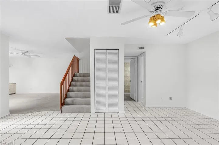 View from the kitchen. Living is left of stair case, louvered doors hide a storage/HWH utility area, laundry room and half bath are on the right.