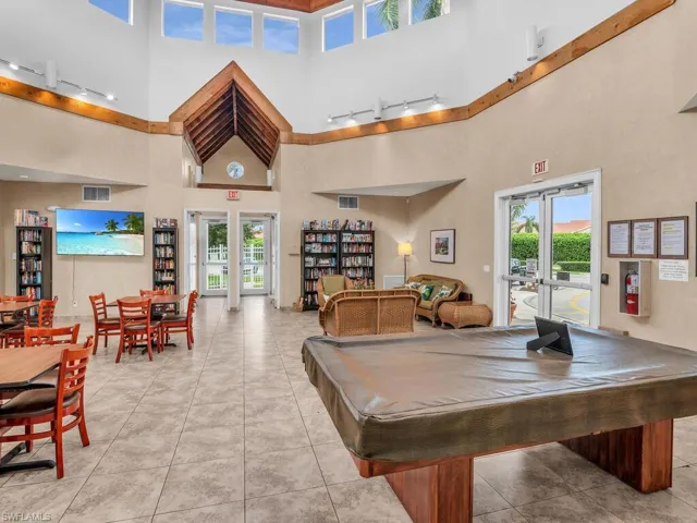 Playroom with a towering ceiling, pool table, light tile patterned floors, and french doors