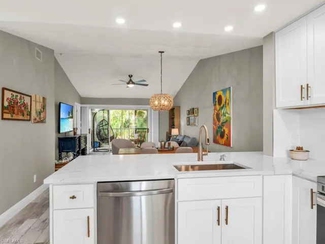 Kitchen with white cabinets, stainless steel appliances, light hardwood / wood-style floors, sink, and kitchen peninsula