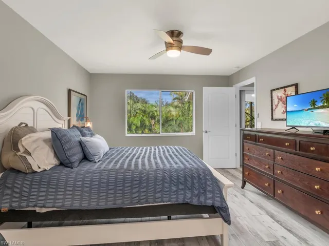 Bedroom with ceiling fan, multiple windows, and light hardwood / wood-style floors