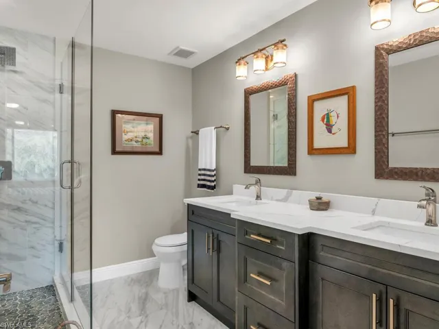 Bathroom featuring vanity, toilet, and a shower with shower door