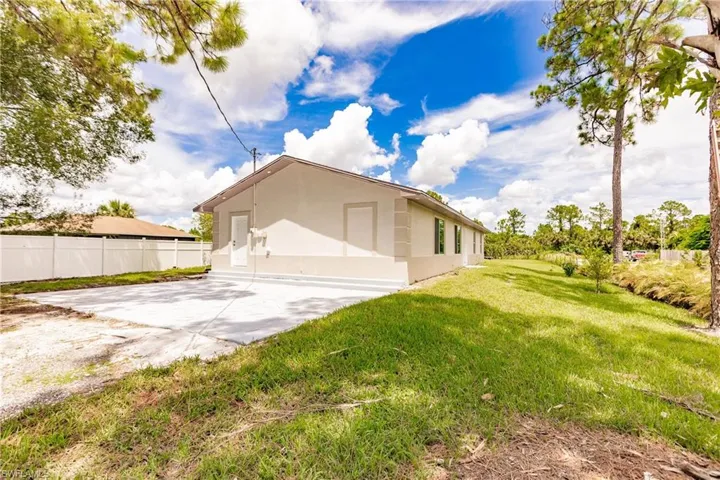 View of property exterior featuring a lawn and a patio area