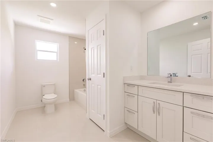 Full bathroom with vanity, toilet, tile patterned floors, and  shower combination