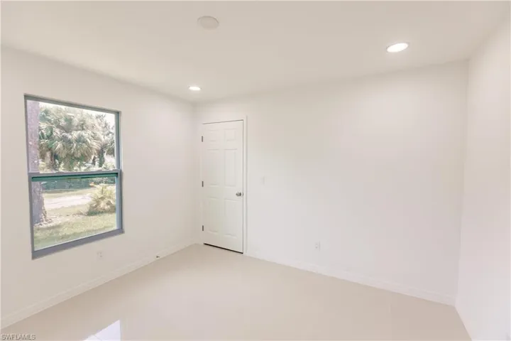 Tiled empty room featuring a healthy amount of sunlight