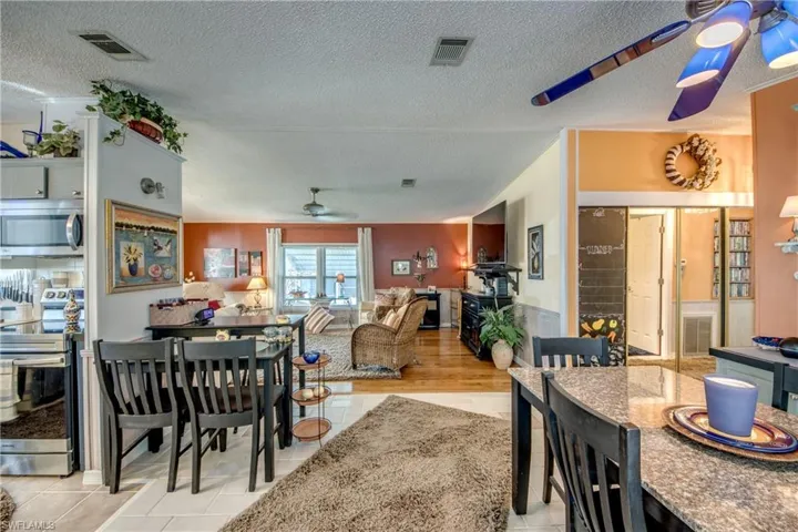 Dining area featuring ceiling fan, a textured ceiling, and light hardwood / wood-style floors