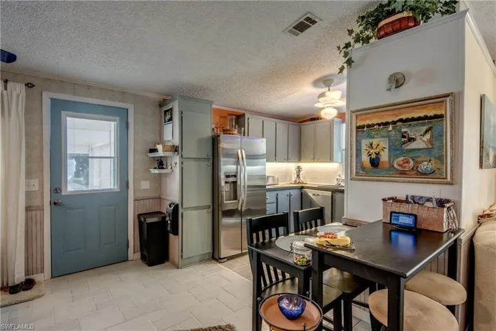 Dining space featuring ornamental molding, a textured ceiling, and ceiling fan