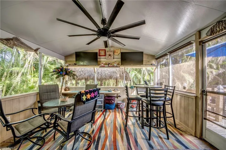 Sunroom featuring a wealth of natural light, ceiling fan, and vaulted ceiling