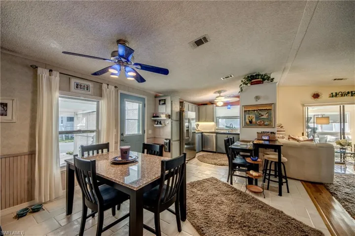 Dining room featuring ceiling fan, a healthy amount of sunlight, sink, and a textured ceiling