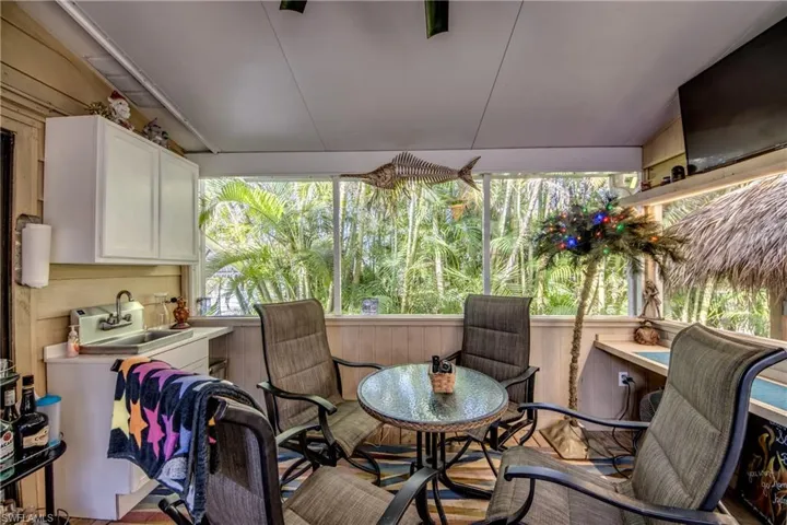 Sunroom featuring lofted ceiling and sink