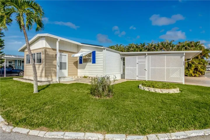 Manufactured / mobile home with a front yard and a carport