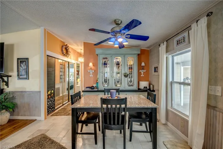 Dining room with a textured ceiling, ceiling fan, and plenty of natural light