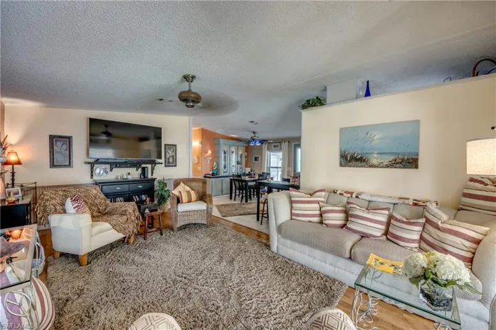 Living room featuring hardwood / wood-style floors, a textured ceiling, and ceiling fan