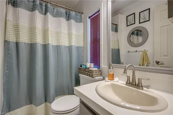 Bathroom featuring tasteful backsplash, vanity, a textured ceiling, and toilet