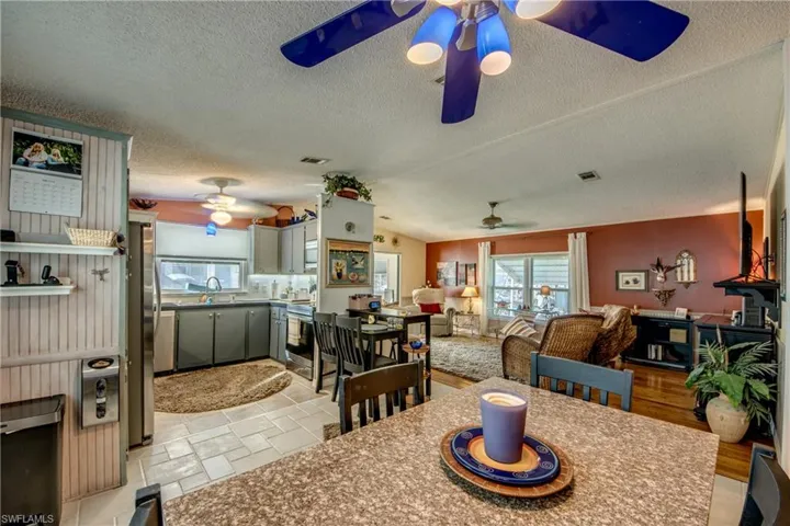 Dining area featuring ceiling fan, a textured ceiling, sink, and light hardwood / wood-style flooring