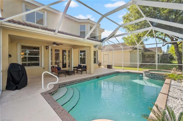 View of pool with french doors, a lanai, grilling area, a patio area, and an in ground hot tub