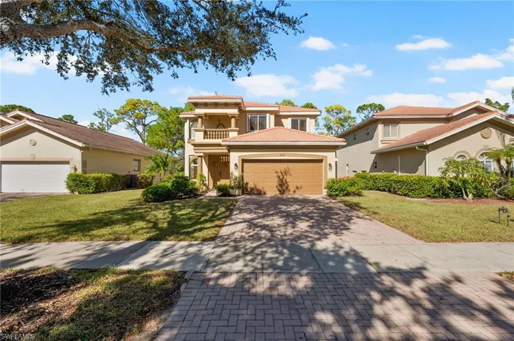 Mediterranean / spanish-style house featuring a front yard, a balcony, and a garage
