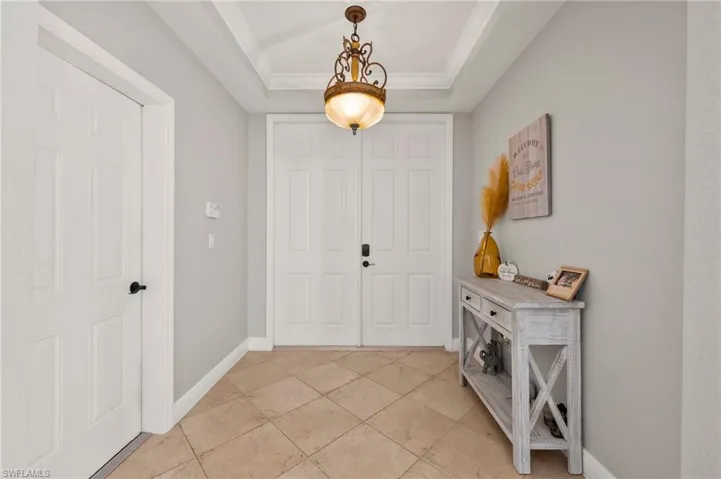 Tiled foyer with a tray ceiling