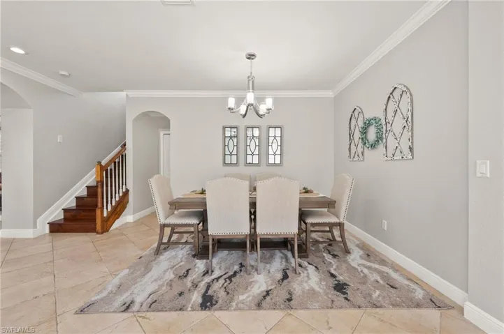 Dining area featuring ornamental molding and a notable chandelier