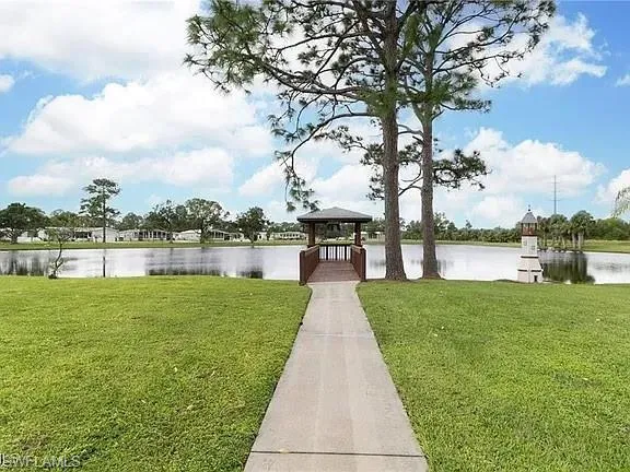 Dock with a gazebo, a yard, and a water view