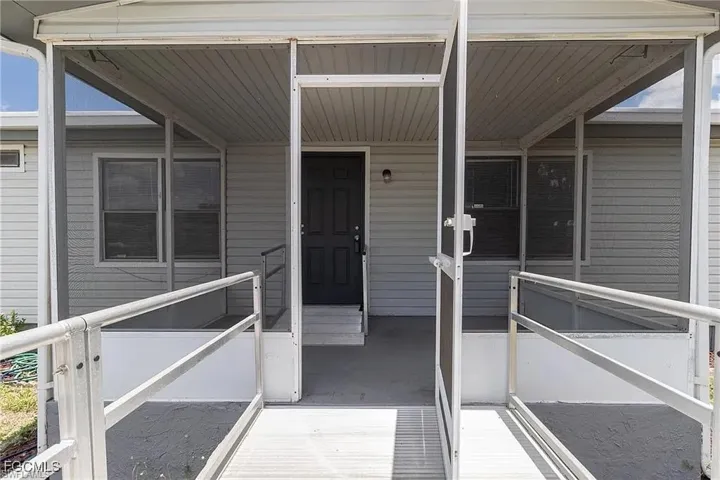 Doorway to property featuring covered porch