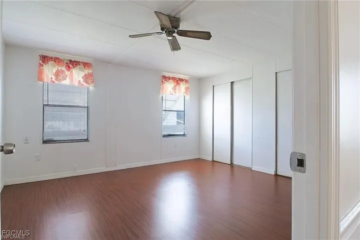 Unfurnished bedroom with wood finished floors and a ceiling fan