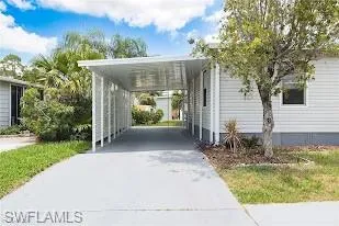 View of property's community featuring concrete driveway and a carport