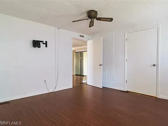 Unfurnished bedroom with dark wood-style flooring and ceiling fan