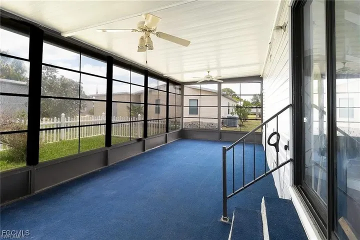 Unfurnished sunroom with ceiling fan