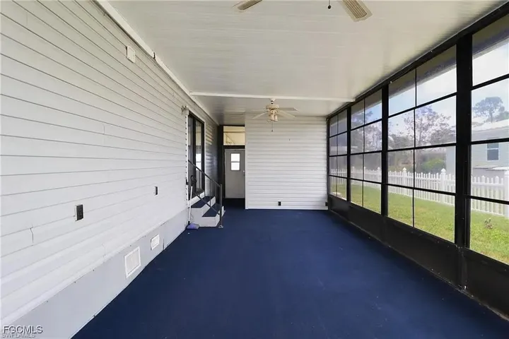 Unfurnished sunroom with ceiling fan