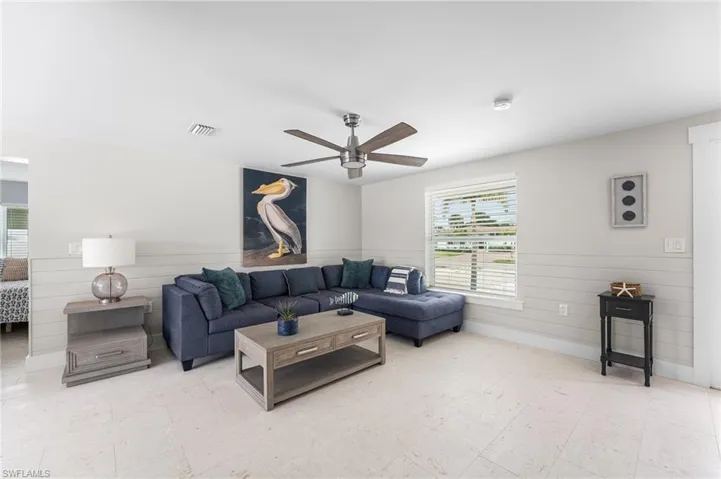 Living area with light tile floors and ceiling fan