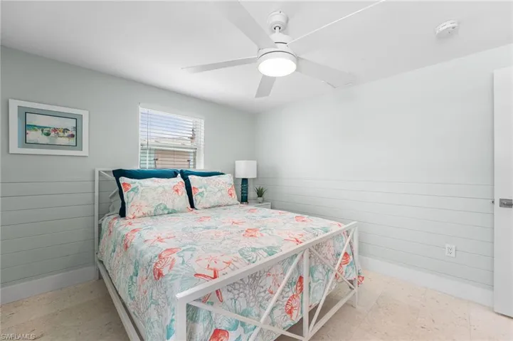 Guest Bedroom featuring multiple windows, ceiling fan, and wainscoting.  Room to sleep 4 in this room