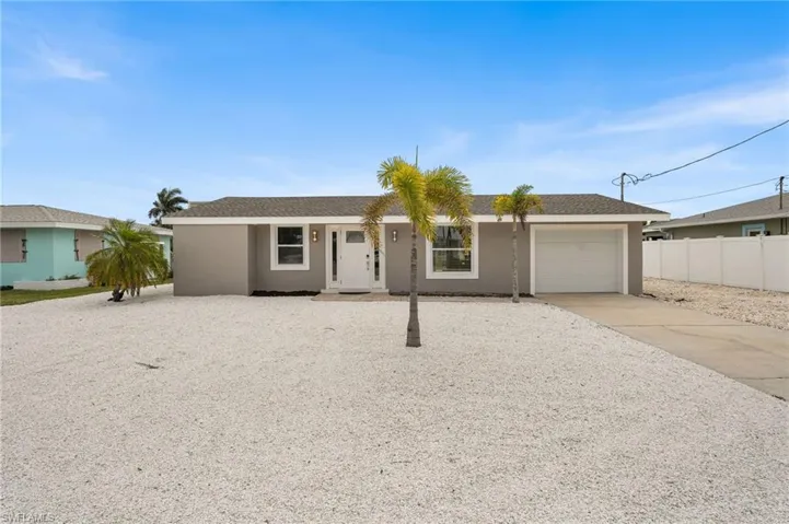 Ranch-style house with concrete driveway, an attached garage, stucco siding, and roof with shingles